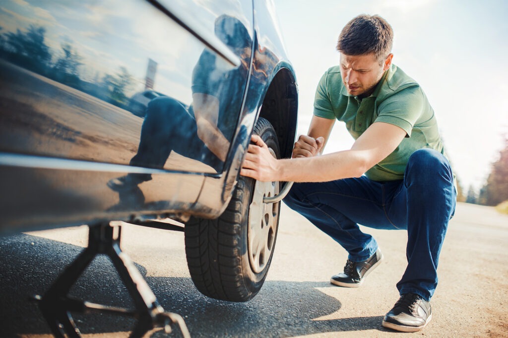 A man is Changing a car tire for better Car Performance