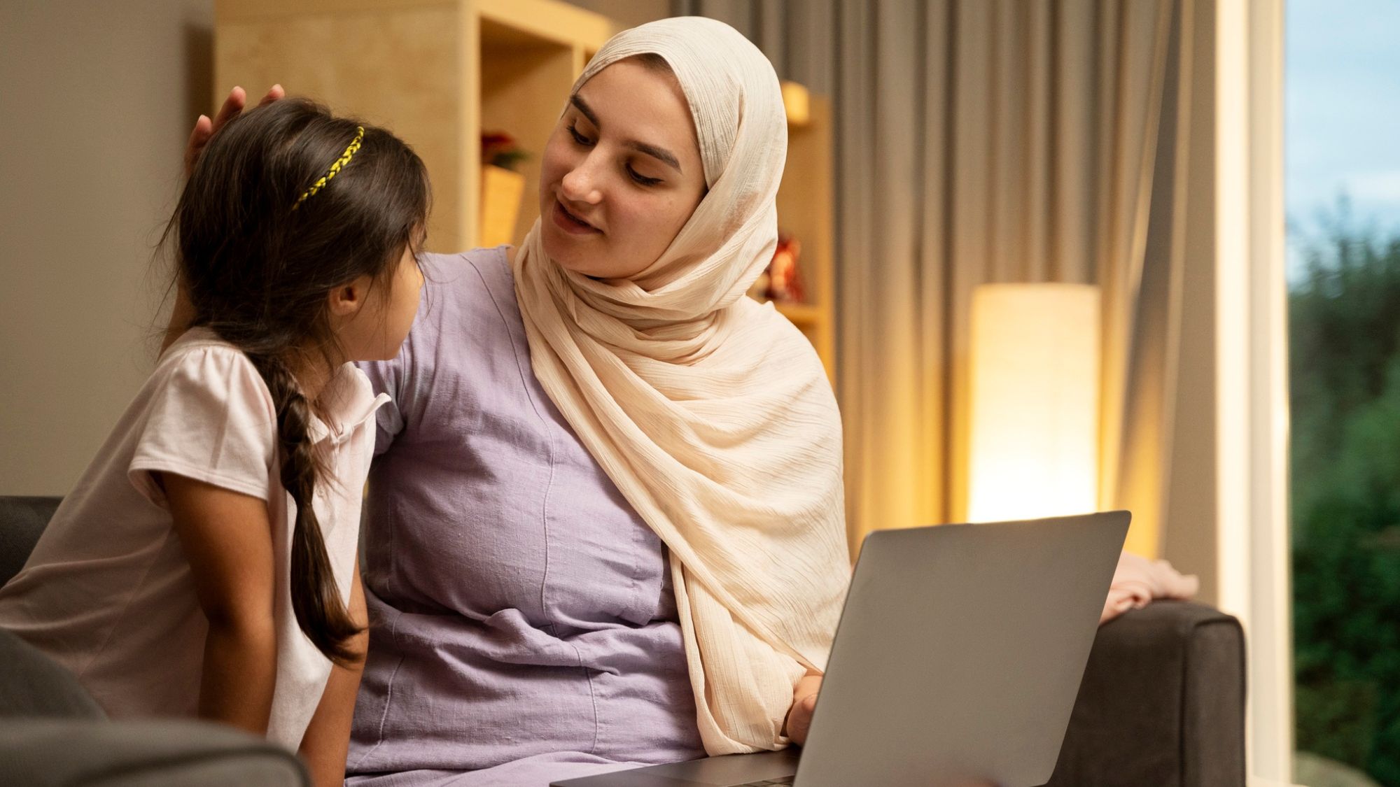 A Muslim lady and her daughter attending online Quran lectures