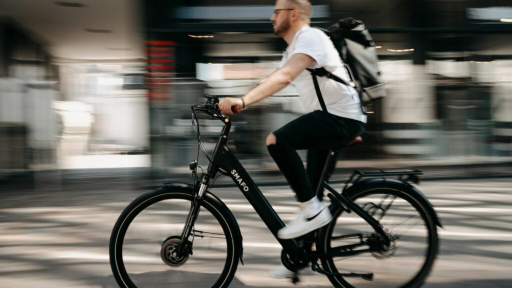 A boy riding his step-thru electric bikes rushing to college