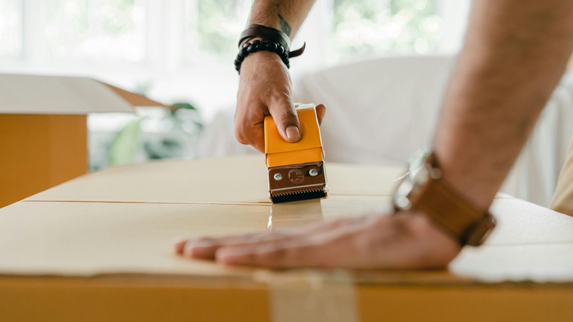 A man taping the cartons and navigating the challenges of apartment moving