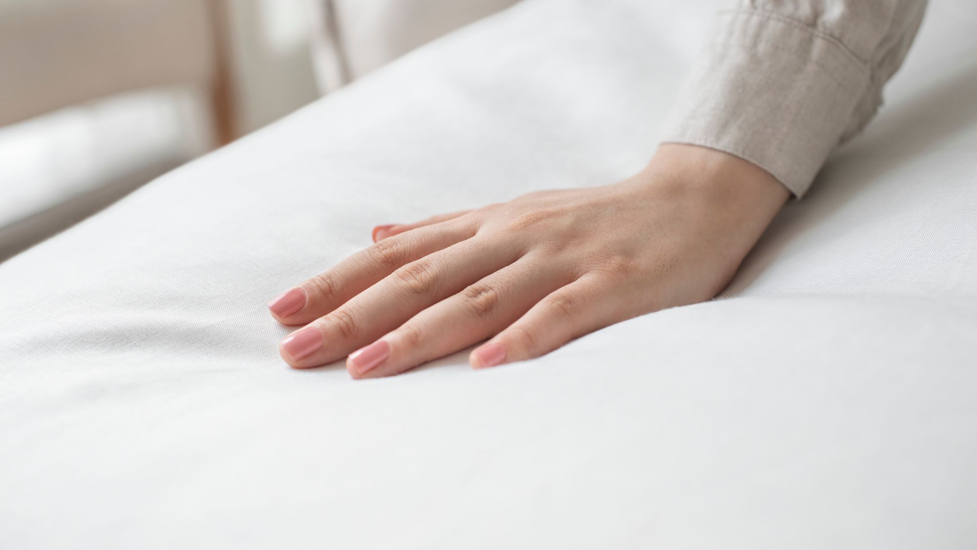 A woman testing a diamond mattress with her hand to improve her night sleep