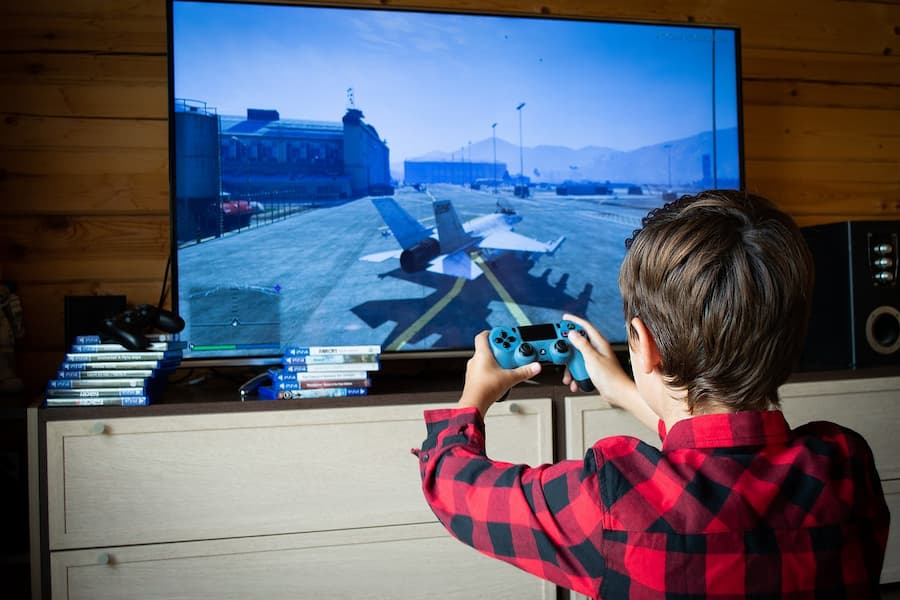 A young boy immersed in video games, focused on the TV screen, showcasing the excitement of gaming with Selenite Games