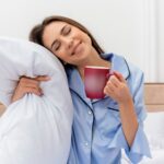 A woman in a blue shirt holds a coffee mug, appearing relaxed and content. tranzzquil
